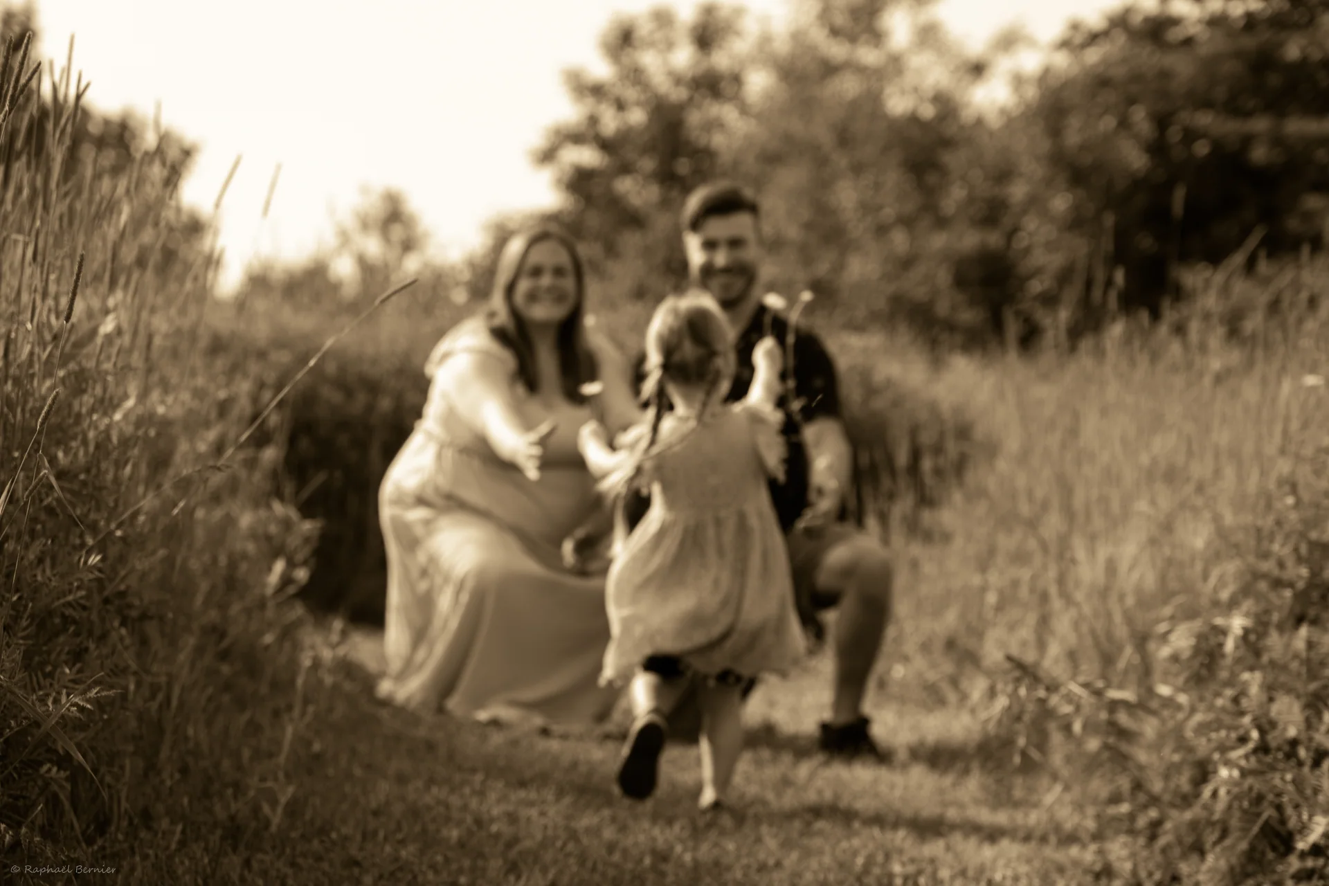 Une famille marche ensemble dans un champ, en noir et blanc.